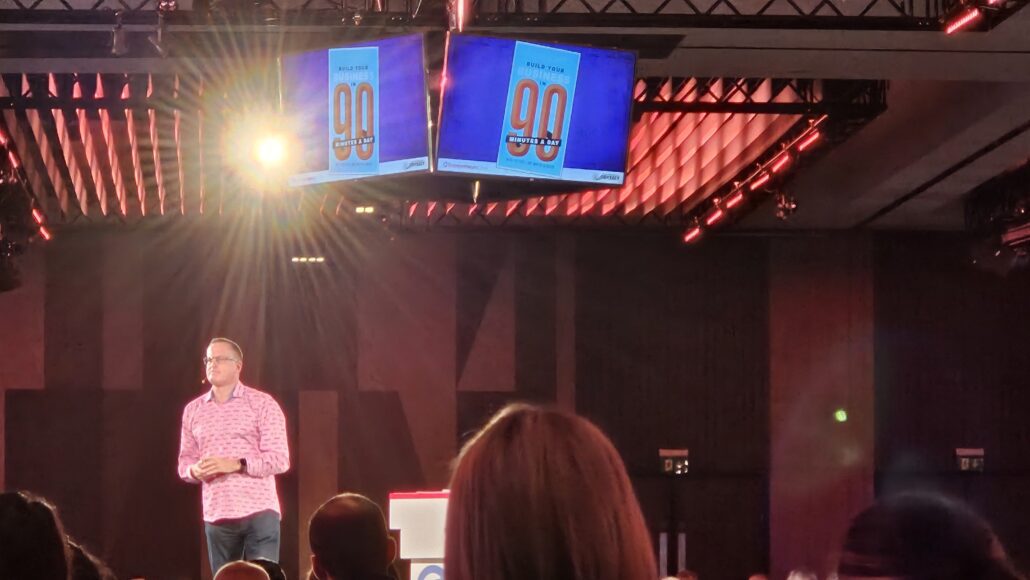 Nigel Botterill speaking on stage about his Build your business in 90 minutes a day book that he wrote with Martin Gladdish